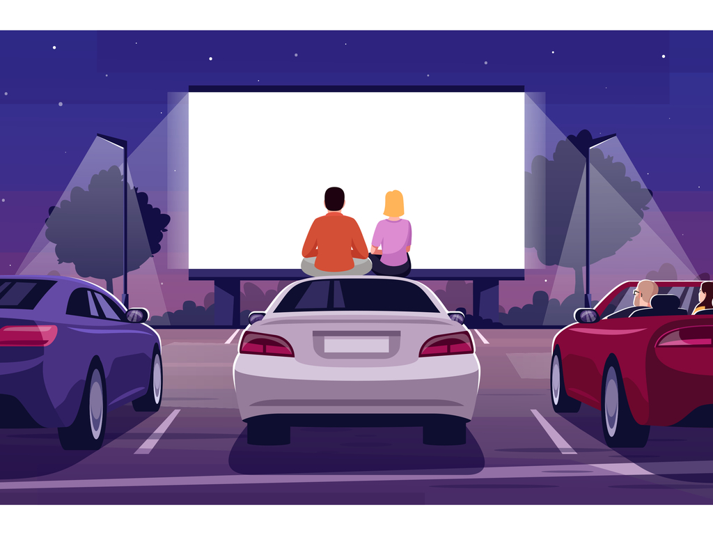 Man and woman sitting on top of a white car looking at a large projector in front of them at a drive-in cinema.